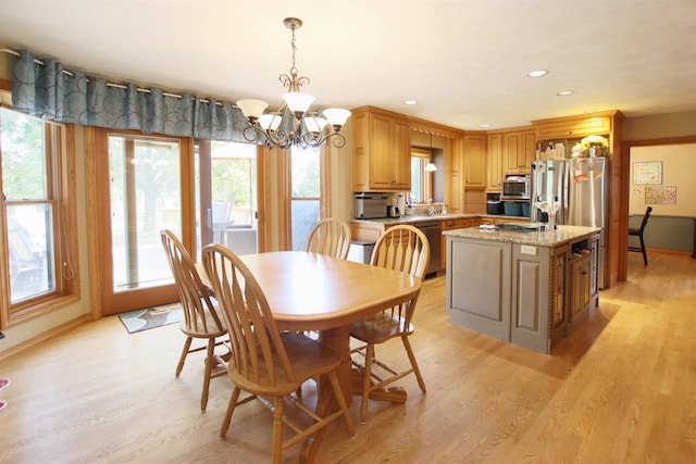 dining space featuring light hardwood / wood-style floors and an inviting chandelier