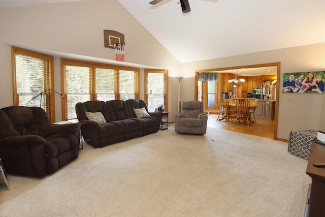 living room featuring carpet, high vaulted ceiling, and ceiling fan with notable chandelier