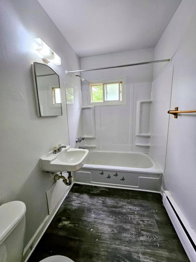 full bathroom featuring sink, a baseboard heating unit, wood-type flooring, toilet, and shower / bathtub combination