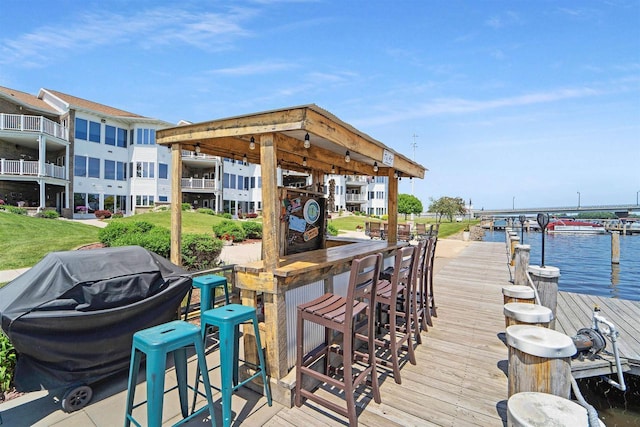 view of dock featuring a water view and an outdoor bar