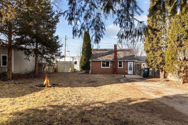 back of house featuring a storage unit