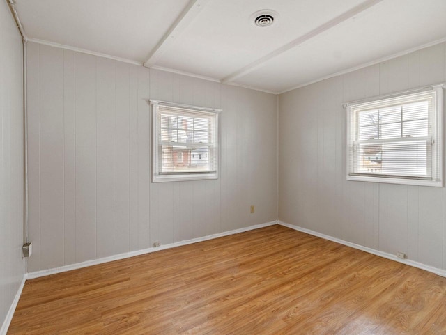 empty room featuring light hardwood / wood-style floors and crown molding