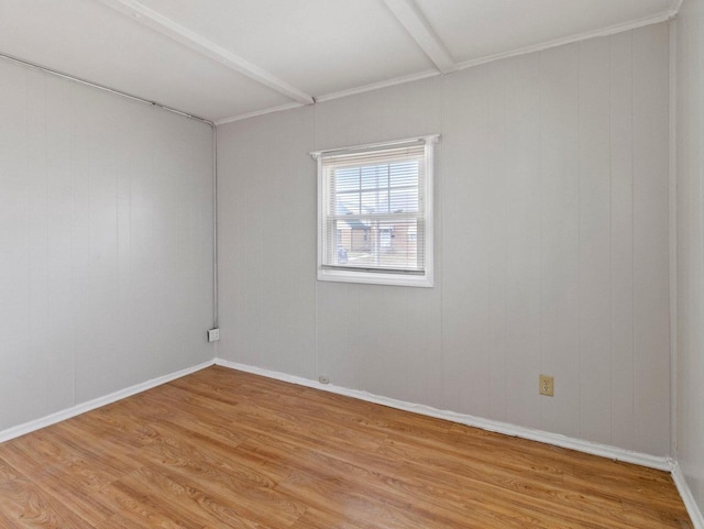 unfurnished room featuring beam ceiling and light wood-type flooring