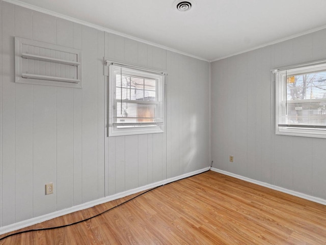 empty room featuring light hardwood / wood-style flooring and ornamental molding