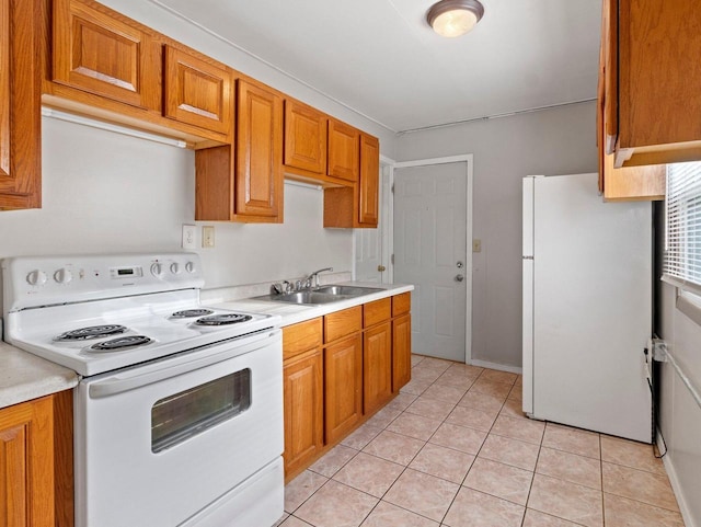 kitchen with light tile patterned floors, white appliances, and sink