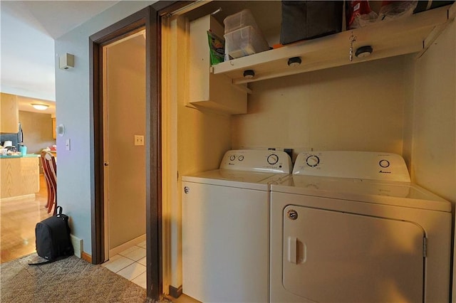 laundry area with light tile patterned floors and washing machine and clothes dryer