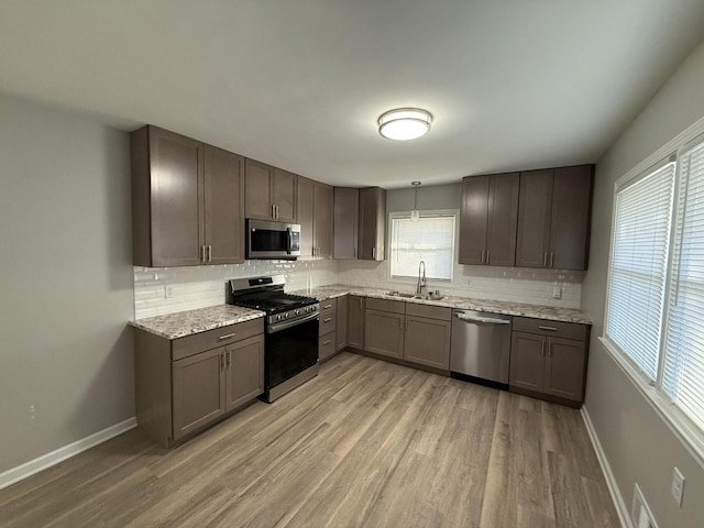 kitchen featuring decorative backsplash, decorative light fixtures, sink, and appliances with stainless steel finishes