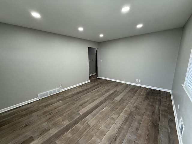 unfurnished room with dark wood-type flooring