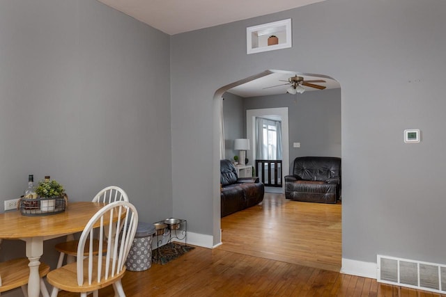 dining area with ceiling fan and wood-type flooring