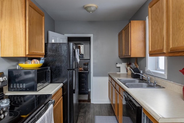 kitchen with dark wood-type flooring, sink, and black appliances