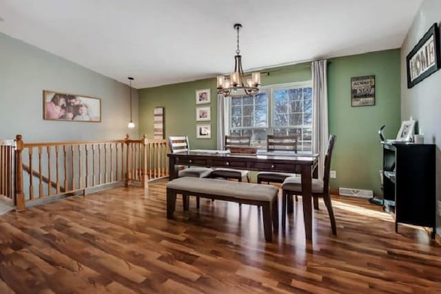 dining area with a chandelier, lofted ceiling, and dark wood-type flooring