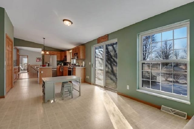 kitchen with a kitchen breakfast bar, stainless steel fridge with ice dispenser, a kitchen island, hanging light fixtures, and lofted ceiling