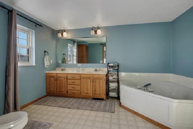 bathroom featuring a bath, vanity, and toilet