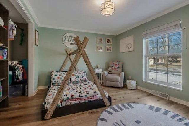 bedroom with hardwood / wood-style floors and ornamental molding