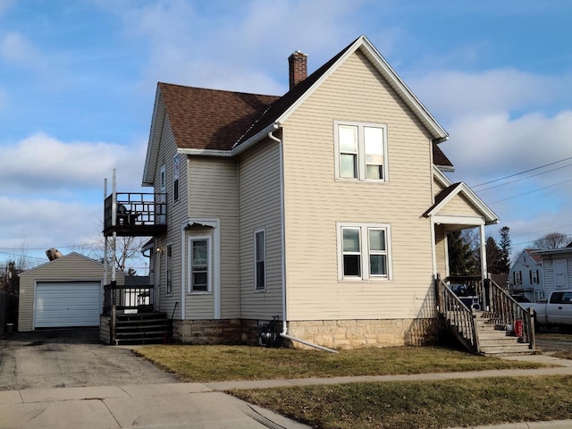 view of property exterior with a lawn, an outbuilding, and a garage