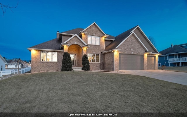 view of front of home featuring driveway, a chimney, a front lawn, a garage, and brick siding