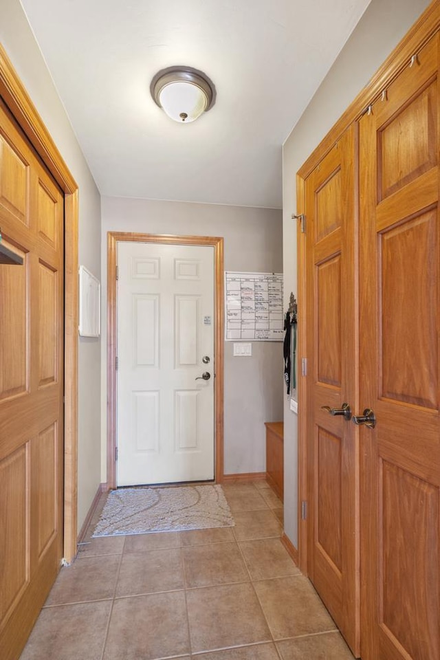 entryway with light tile patterned floors and baseboards