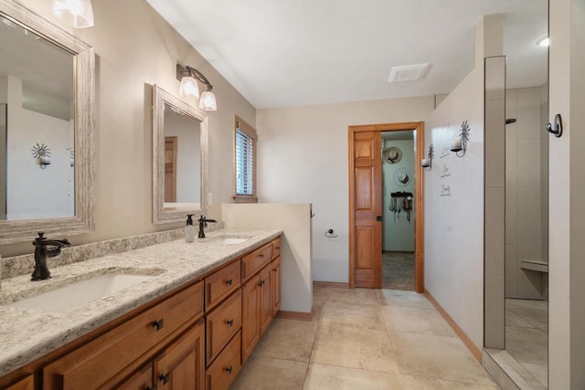 full bathroom with double vanity, tile patterned floors, baseboards, and a sink