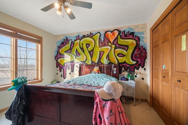 carpeted bedroom with ceiling fan and a closet