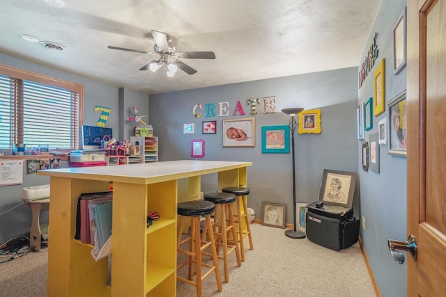 bar featuring visible vents, ceiling fan, light colored carpet, and baseboards