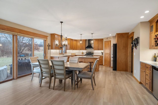 dining space with light hardwood / wood-style floors and a notable chandelier