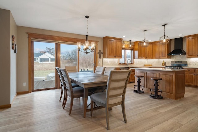 dining space with light hardwood / wood-style flooring and a notable chandelier