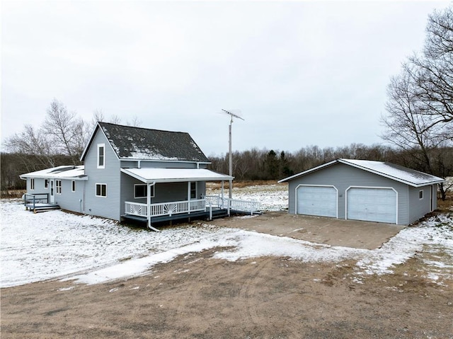 view of front of house featuring a porch, a garage, and an outbuilding