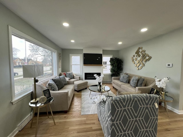 living room featuring a baseboard radiator and light hardwood / wood-style floors