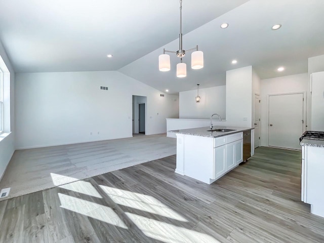 kitchen featuring decorative light fixtures, white cabinetry, sink, a notable chandelier, and light hardwood / wood-style flooring