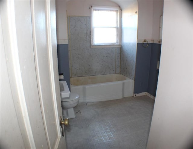 bathroom featuring tile patterned flooring, toilet, and a bathtub