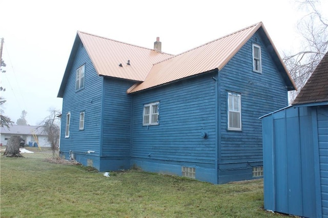 view of property exterior with a yard and a storage unit