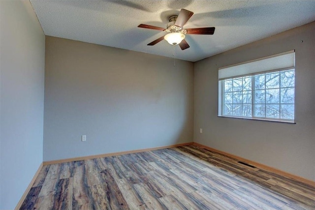 empty room featuring hardwood / wood-style floors, ceiling fan, and a textured ceiling