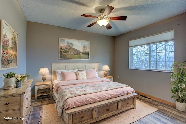 bedroom featuring ceiling fan, a textured ceiling, and light wood-type flooring