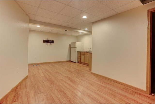 unfurnished room featuring a paneled ceiling, light hardwood / wood-style floors, and sink