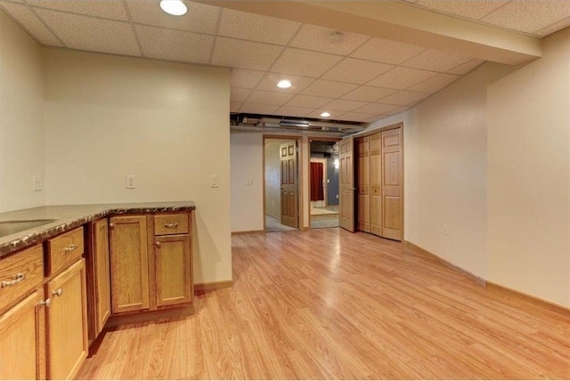 kitchen with a paneled ceiling and light hardwood / wood-style floors