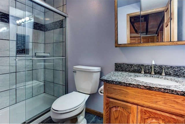 bathroom with vanity, a shower with shower door, and toilet