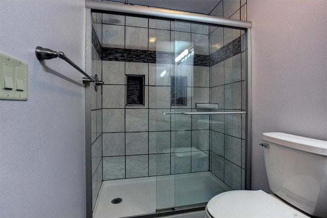 bathroom featuring walk in shower and toilet