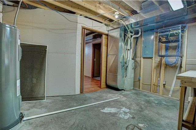 basement featuring electric water heater, electric panel, and heating unit