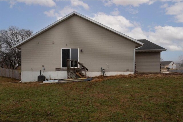 back of house featuring a yard and central AC