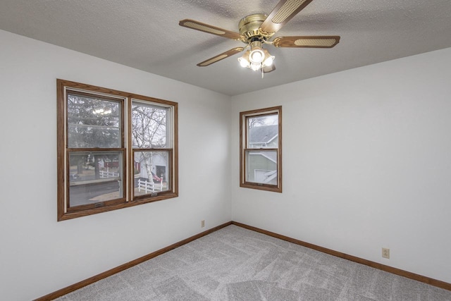 carpeted spare room with ceiling fan and a textured ceiling