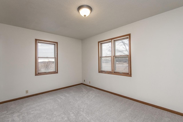 carpeted spare room with a textured ceiling