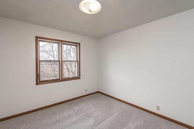 unfurnished room featuring carpet flooring and a textured ceiling