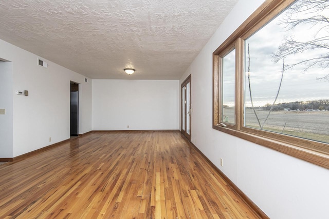 spare room with wood-type flooring and a textured ceiling