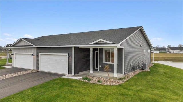 view of front of property with a garage, cooling unit, and a front lawn