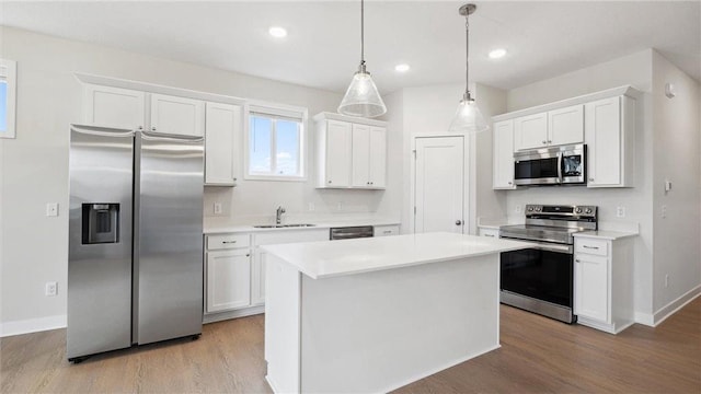 kitchen featuring white cabinetry, stainless steel appliances, and hanging light fixtures