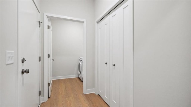 hallway with light wood-type flooring and washer and dryer