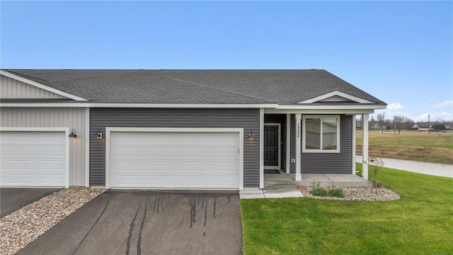 ranch-style house featuring a front yard and a garage