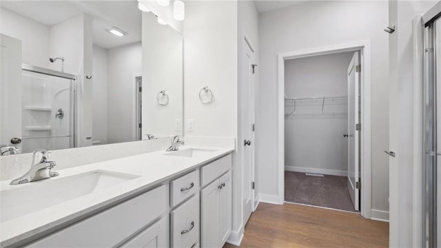 bathroom featuring a shower with shower door, hardwood / wood-style flooring, and vanity