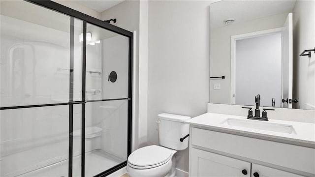 bathroom featuring vanity, toilet, and a shower with shower door