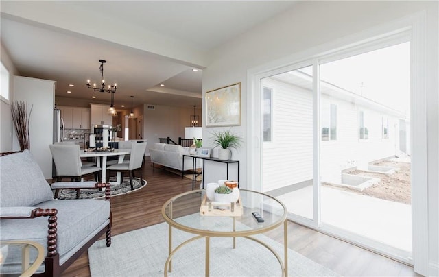 living room featuring hardwood / wood-style flooring and an inviting chandelier